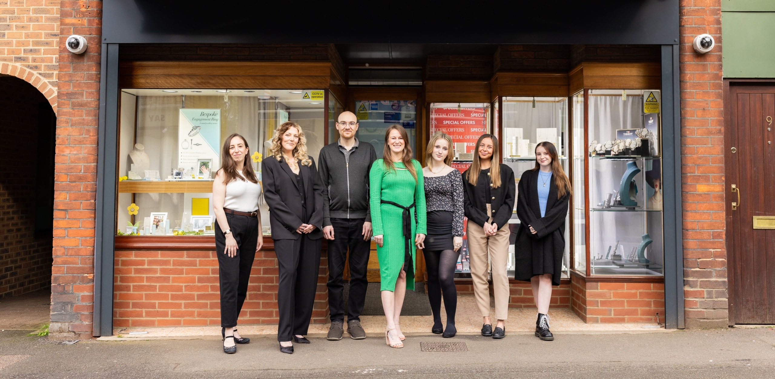 team standing in front of the shop front